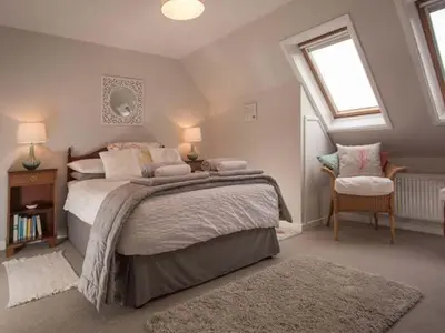 a bedroom with a large bed and a window at Kilcarreg in Wadebridge