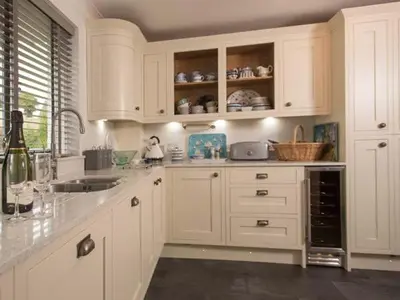 a white kitchen with white cabinets and a sink at Kilcarreg in Wadebridge