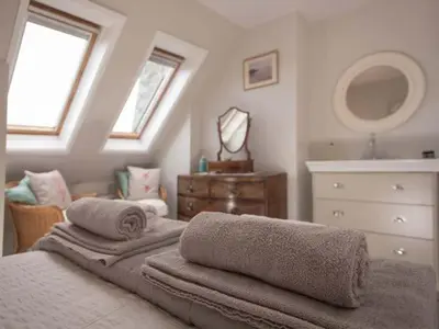 a bedroom with two towels on a bed and a dresser at Kilcarreg in Wadebridge