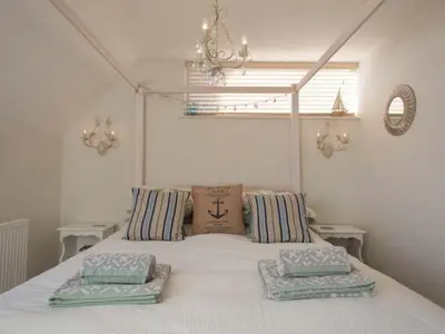 a bedroom with a white bed with pillows on it at Kilcarreg in Wadebridge