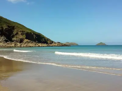 a beach with waves coming in from the ocean at Kilcarreg in Wadebridge