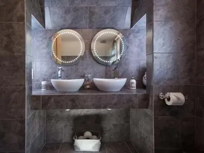 a bathroom with two sinks and two mirrors at Kilcarreg in Wadebridge