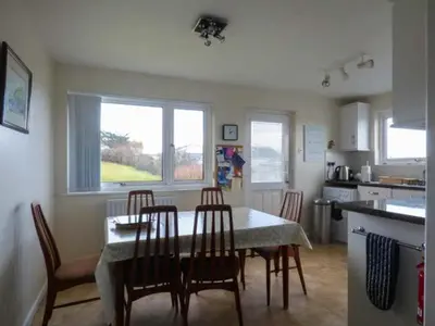 a kitchen with a table and chairs in a kitchen at Godolphin in Wadebridge