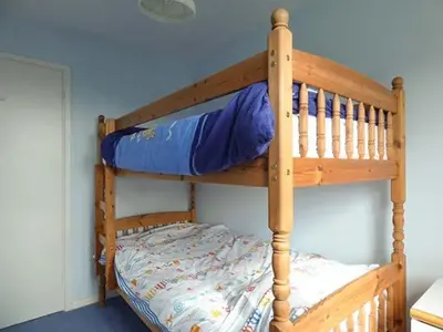 two bunk beds in a room with a blue wall at Godolphin in Wadebridge