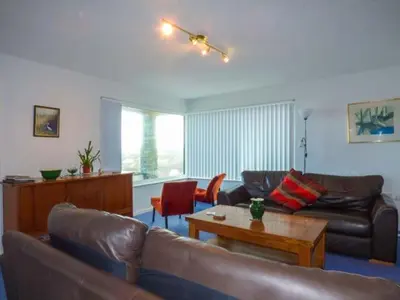 a living room with a leather couch and a table at Godolphin in Wadebridge