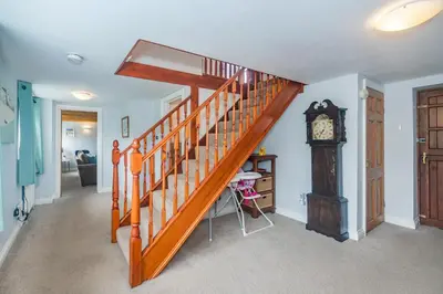 a staircase in a house with a grandfather clock at Penbarden Barn in Bude