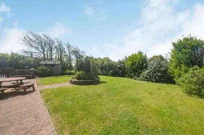a backyard with a picnic table and a lawn at Penbarden Barn in Bude