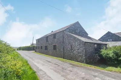 an old stone building on a dirt road at Penbarden Barn in Bude