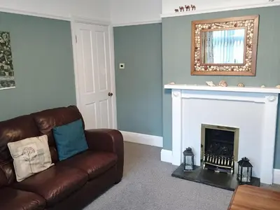 a living room with a couch and a fireplace at Pendeen in Wadebridge