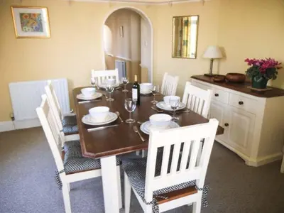 a dining room table with white chairs and a table and chairsktop at Pendeen in Wadebridge
