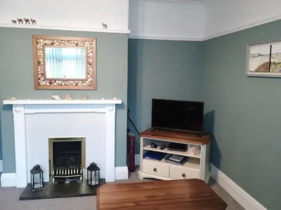 a living room with a fireplace and a television at Pendeen in Wadebridge