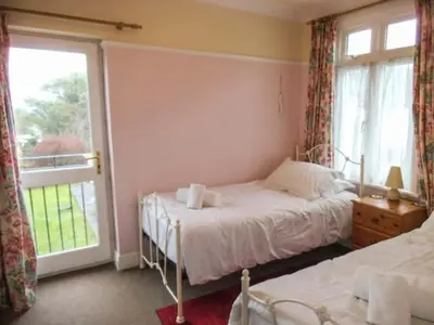 a bedroom with two beds and a window at Pendeen in Wadebridge