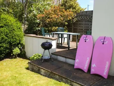 a pair of pink snowboards next to a table and a grill at Pendeen in Wadebridge