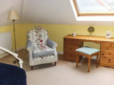 a bedroom with a chair and a dresser and a desk at Pendeen in Wadebridge