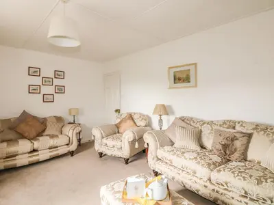 a living room with two couches and a table at Penrose Farm Cottage in Saint Keverne