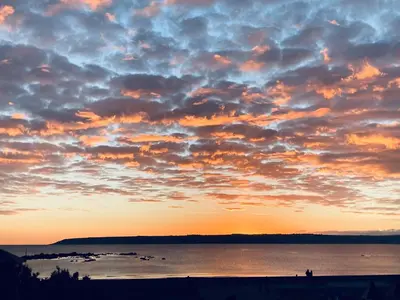 a sunset over a body of water with clouds at Sea Breeze in Marazion