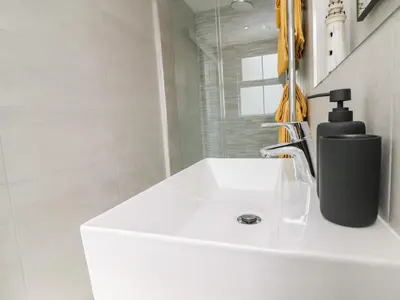 a white bathroom sink with a black soap dispenser on it at Sea Breeze in Marazion