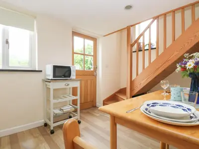 a dining room with a table and a tv at Little Hamlin in Callington