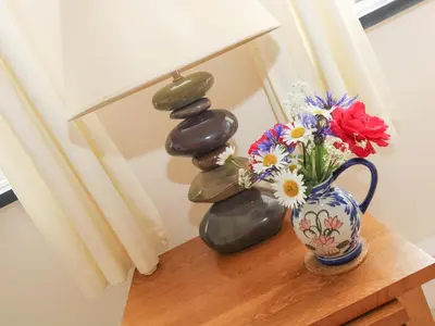 a table with a vase of flowers and rocks at Little Hamlin in Callington