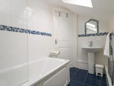 a white bathroom with a tub and a sink at Little Hamlin in Callington