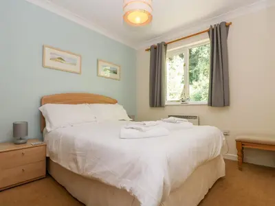 a bedroom with a large white bed and a window at Fox's Walk in Falmouth