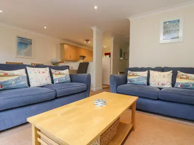 a living room with blue couches and a coffee table at Fox's Walk in Falmouth