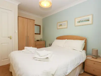 a bedroom with a white bed with towels on it at Fox's Walk in Falmouth