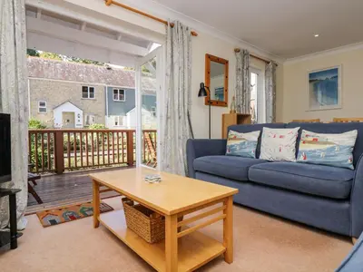 a living room with a blue couch and a table at Fox's Walk in Falmouth