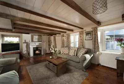 a living room with a couch and a fireplace at Trevara, Marazion in Marazion