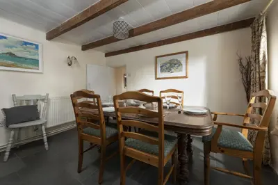a dining room with a wooden table and chairs at Trevara, Marazion in Marazion