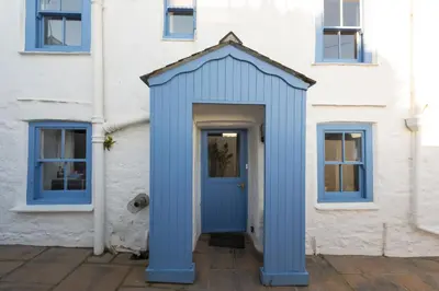 a blue door on the side of a white building at Trevara, Marazion in Marazion
