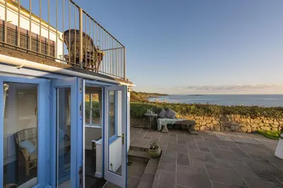 a house with a balcony and a view of the ocean at Trevara, Marazion in Marazion