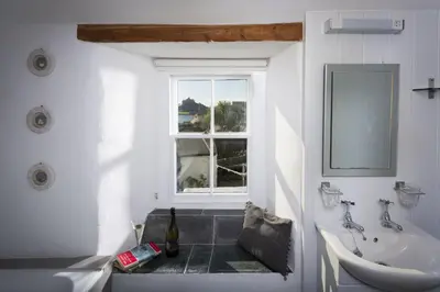 a bathroom with a sink and a tub and a window at Trevara, Marazion in Marazion