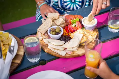 a picnic table with a plate of food on it at Bejowan Cornish Cottage in Newquay