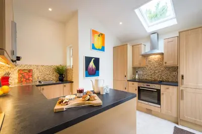 a kitchen with a counter with a cutting board in it at Bejowan Cornish Cottage in Newquay