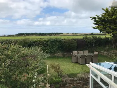 a view of a garden with chairs and a fence at Bejowan Cornish Cottage in Newquay