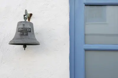 an old bell hanging on the side of a building at Little Trevara, Marazion in Marazion