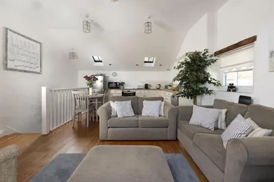 a living room with two couches and a kitchen at Little Trevara, Marazion in Marazion