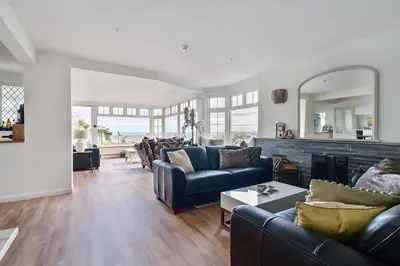 a living room with couches and a fireplace at Lamorna Lodge in St Ives