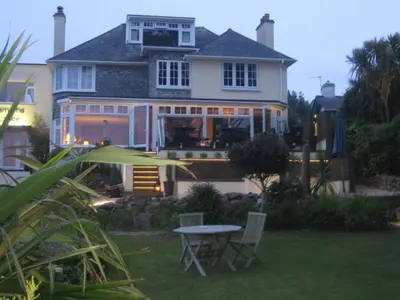 a house with a table and chairs in the yard at Lamorna Lodge in St Ives