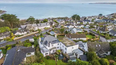 an aerial view of a residential neighborhood with houses and the ocean at Lamorna Lodge in St Ives