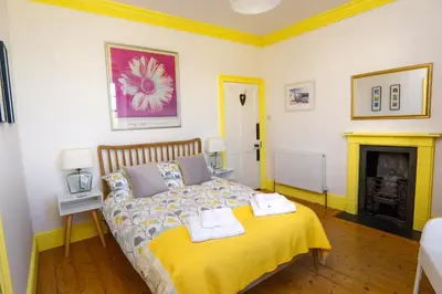 a bedroom with a bed with two towels on it at Ivy House Cornwall B&B in St Austell