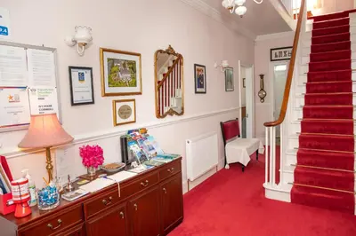 a room with a desk and a red carpet at Ivy House Cornwall B&B in St Austell