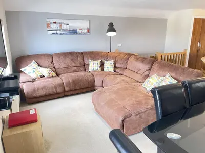 a brown leather couch in a living room at Lews Lookout in St Ives