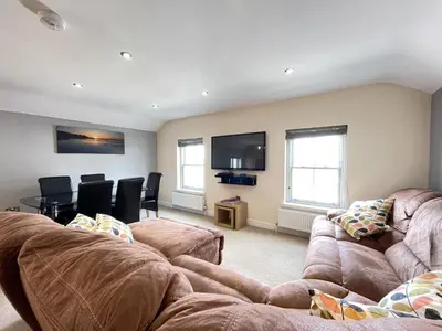 a living room with two couches and a tv at Lews Lookout in St Ives