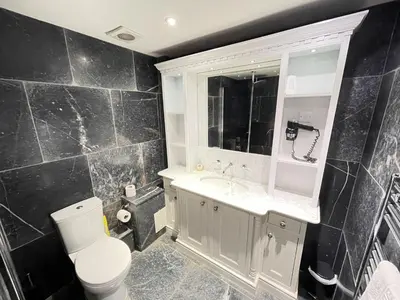 a black bathroom with a toilet and a sink at Lews Lookout in St Ives