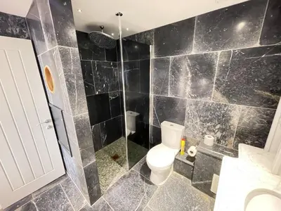 a bathroom with a toilet and a glass shower at Lews Lookout in St Ives
