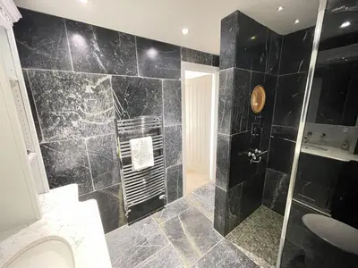 a black bathroom with a shower and a sink at Lews Lookout in St Ives