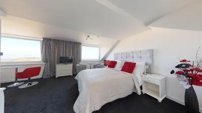 a bedroom with a bed and a desk and a television at Golden Hind in St Ives