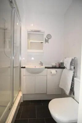 a white bathroom with a sink and a shower at Golden Hind in St Ives